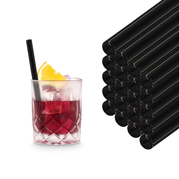 Black 15 cm HALM glass straws stacked beside a red cocktail in a tumbler