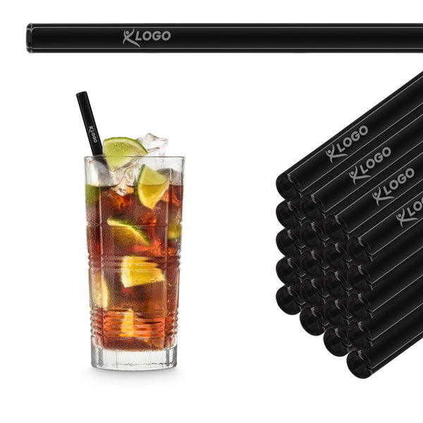 Black 20 cm HALM glass straws with sample logo engraving stacked beside a long drink with limes
